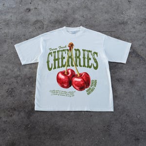 Puede incluir: Camiseta blanca con un gr&aacute;fico de dos cerezas rojas y el texto "Farm Fresh Cherries Hand Picked Natures Candy".