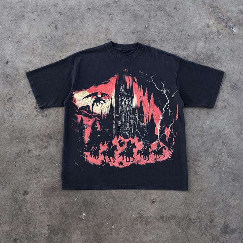 May include: Black t-shirt with a graphic print of a castle, a dragon, and horses in a red and black color scheme.