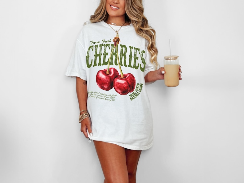 Puede incluir: Camiseta blanca con un gr&aacute;fico de dos cerezas rojas y el texto "Farm Fresh Cherries Hand Picked Nature's Candy".