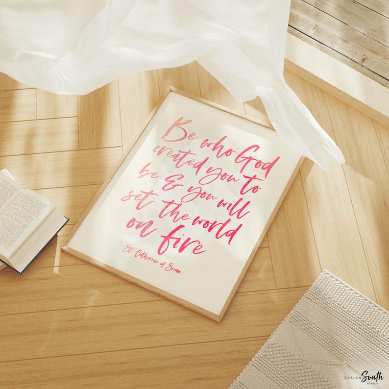May include: Three framed prints with a tropical theme. The prints feature pink flamingos, green monstera leaves, and a pink pineapple. The center print has a pink quote that reads 'Be who God created you to be & you will set the world on fire.' The quote is attributed to St. Catherine of Siena.