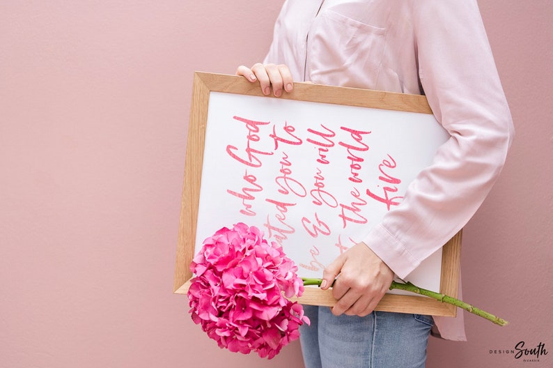 May include: Three framed prints with a tropical theme. The prints feature pink flamingos, green monstera leaves, and a pink pineapple. The center print has a pink quote that reads 'Be who God created you to be & you will set the world on fire.' The quote is attributed to St. Catherine of Siena.