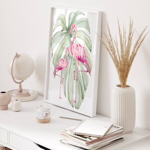 May include: Three framed prints with a tropical theme. The prints feature pink flamingos, green monstera leaves, and a pink pineapple. The center print has a pink quote that reads 'Be who God created you to be & you will set the world on fire.' The quote is attributed to St. Catherine of Siena.