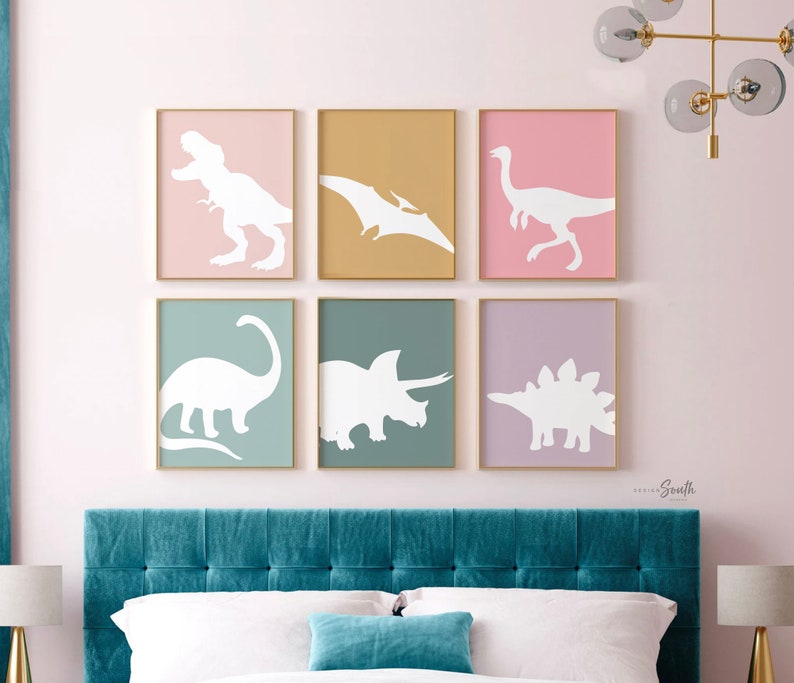 Adorable dinosaur art prints designed for a little girls room, featuring playful dinosaurs in shades of pink, teal, and purple. These vibrant and fun dinosaur illustrations are perfect for adding a touch of adventure and charm to toddler wall decor. Ideal for a girl's nursery, bedroom, or playroom, these art prints create a whimsical and colorful space. Perfect for girls who love dinosaurs, this wall decor adds personality and joy to any room setting, making it a delightful addition to her space