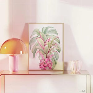 May include: Three framed prints with a tropical theme. The prints feature pink flamingos, green monstera leaves, and a pink pineapple. The center print has a pink quote that reads 'Be who God created you to be & you will set the world on fire.' The quote is attributed to St. Catherine of Siena.