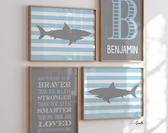 May include: Four framed prints with a blue and white striped background. The top left print features a grey shark silhouette. The top right print features a large grey letter "B" with a blue outline and the name "Benjamin" below. The bottom left print features a grey text box with the words "Always remember, you are braver than you believe, stronger than you seem, smarter than you think, and loved more than you will ever know." The bottom right print features a grey shark silhouette.