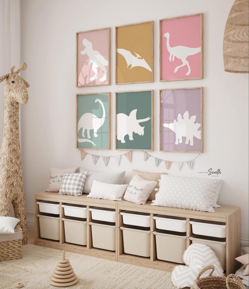 Adorable dinosaur art prints designed for a little girls room, featuring playful dinosaurs in shades of pink, teal, and purple. These vibrant and fun dinosaur illustrations are perfect for adding a touch of adventure and charm to toddler wall decor. Ideal for a girl's nursery, bedroom, or playroom, these art prints create a whimsical and colorful space. Perfect for girls who love dinosaurs, this wall decor adds personality and joy to any room setting, making it a delightful addition to her space