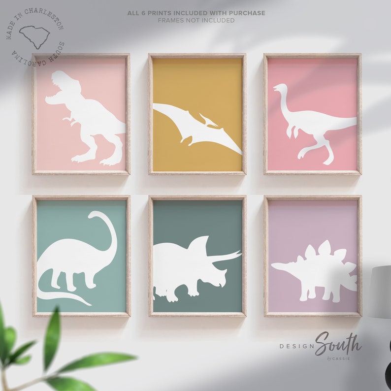 Adorable dinosaur art prints designed for a little girls room, featuring playful dinosaurs in shades of pink, teal, and purple. These vibrant and fun dinosaur illustrations are perfect for adding a touch of adventure and charm to toddler wall decor. Ideal for a girl's nursery, bedroom, or playroom, these art prints create a whimsical and colorful space. Perfect for girls who love dinosaurs, this wall decor adds personality and joy to any room setting, making it a delightful addition to her space