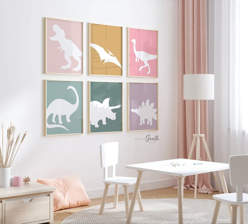 Adorable dinosaur art prints designed for a little girls room, featuring playful dinosaurs in shades of pink, teal, and purple. These vibrant and fun dinosaur illustrations are perfect for adding a touch of adventure and charm to toddler wall decor. Ideal for a girl's nursery, bedroom, or playroom, these art prints create a whimsical and colorful space. Perfect for girls who love dinosaurs, this wall decor adds personality and joy to any room setting, making it a delightful addition to her space