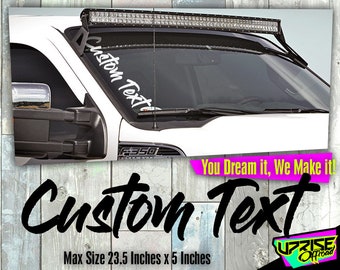 Puede incluir: Calcomanía de texto personalizado blanco en el parabrisas de una camioneta blanca. La calcomanía mide 23,5 pulgadas por 5 pulgadas. El texto dice "Custom Text".