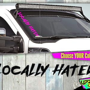 May include: A white truck with a black light bar on the roof. The truck has a pink decal on the windshield that says "Locally Hated". The truck is parked in front of a wooden wall. The text "Choose YOUR Color!" is visible below the truck. The text "LOCALLY HATRED" is visible below the truck in a black, stylized font.
