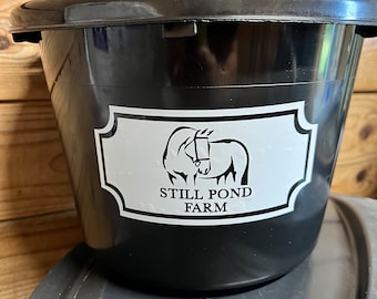 May include: A black plastic bucket with a white label that says "Still Pond Farm". The label features a black silhouette of a horse with a bridle.
