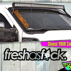 May include: Orange "freshasfck." windshield decal on a white truck. The decal is vertical and angled. The image also shows a black and white decal with the same text and a "Choose YOUR Color!" banner.