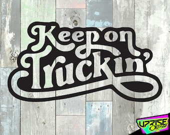 Puede incluir: Calcomanía de vinilo en blanco y negro con el texto "Keep on Truckin'" en una fuente estilizada. La calcomanía está sobre un fondo de madera.