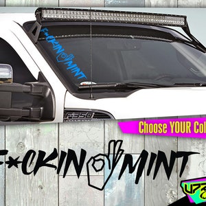 May include: A white truck with a blue windshield decal that reads "F*CKIN MINT" with an OK hand gesture. The image also shows a light bar and the text "CHOOSE YOUR COLOR!" in a pink banner.