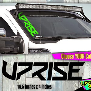 May include: Black and green "UPRISE" decal for a truck windshield. The decal is 16.5 inches by 4 inches.