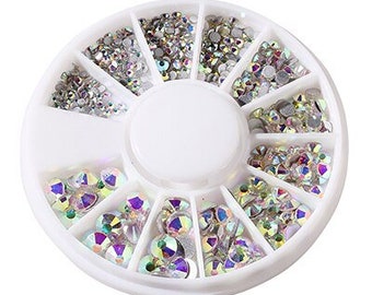 May include: A white wheel with 12 compartments filled with iridescent rhinestones. Each compartment contains a different size and shape of rhinestones.