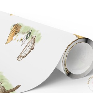 Rolled sheet of Classic Winnie the Pooh-themed wrapping paper partially unrolled on a white surface. The paper showcases charming watercolor scenes of Pooh, Piglet, and their friends in soft pastel tones with grassy patches and woodland details.
