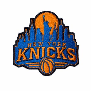 Może przedstawiać: Haftowana naszywka z logo New York Knicks w kolorze niebieskim i pomarańczowym. Wzór przedstawia niebieską sylwetkę panoramy miasta na tle pomarańczowego, kolistego słońca, z napisem NEW YORK KNICKS i grafiką piłki do koszykówki na dole.