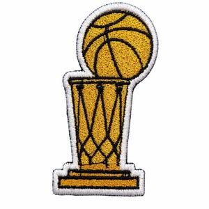 May include: An embroidered patch featuring a gold basketball trophy design. The trophy consists of a gold basketball resting on a gold net structure with black stitching details, all outlined in a thick white border against a plain background.
