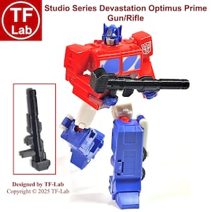 May include: A red and blue Optimus Prime action figure from the Transformers Studio Series Devastation line. The figure is holding a black gun/rifle. The figure is in robot mode and is standing on a white background. The text "Studio Series Devastation Optimus Prime Gun/Rifle" is written above the figure. The text "Designed by TF-Lab Copyright © 2025 TF-Lab" is written below the figure.