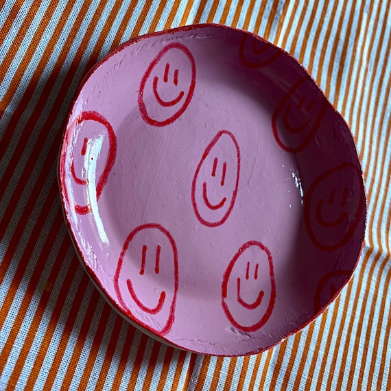 pink jumper with red smiley faces