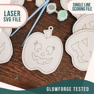 K&ouml;nnte beinhalten: Eine Einzellinien-Scoring-Datei f&uuml;r ein K&uuml;rbis-f&ouml;rmiges Bastelprojekt. Die Datei liegt auf einer Holzoberfl&auml;che mit Farbe und Pinseln. Der Text "LASER SVG FILE" und "SINGLE LINE SCORING FILE" ist sichtbar. Der Text "GLOWFORGE TESTED" ist ebenfalls sichtbar.