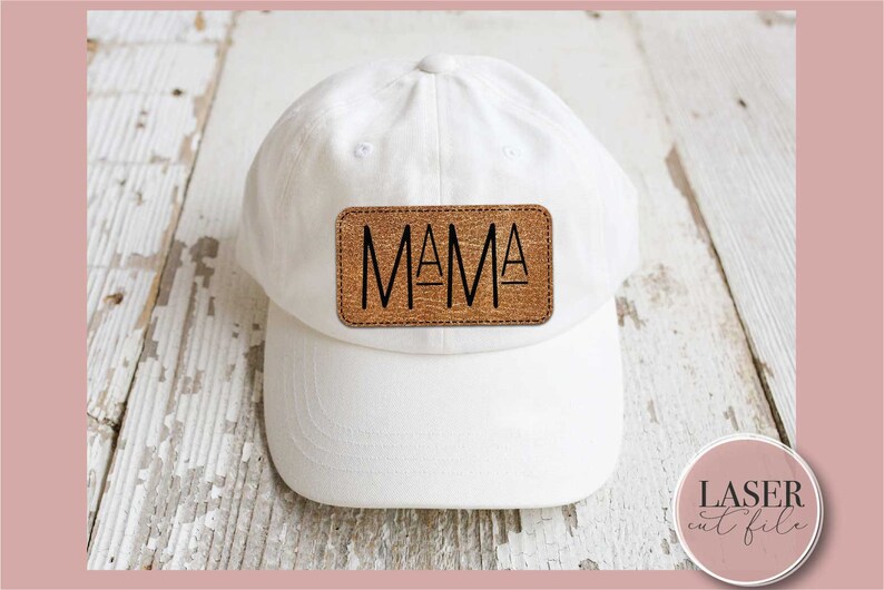 K&ouml;nnte beinhalten: Wei&szlig;e Baseballkappe mit einem braunen Lederpatch, auf dem in schwarzen Buchstaben "MAMA" steht.