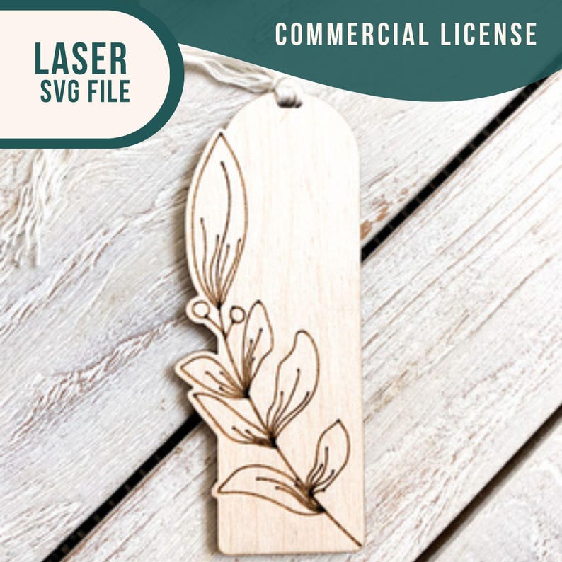 May include: A laser cut wooden bookmark with a delicate floral design. The bookmark is light brown and has a white string attached to the top. The text "COMMERCIAL LICENSE" is visible in the top right corner of the image.