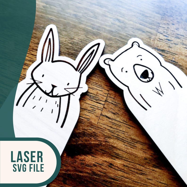 May include: Two laser cut wooden bookmarks, one with a rabbit design and the other with a bear design. Both bookmarks are white with black outlines.