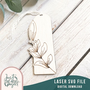 May include: A wooden bookmark with a laser-cut design of a leafy branch. The bookmark is white and has a string attached to the top.