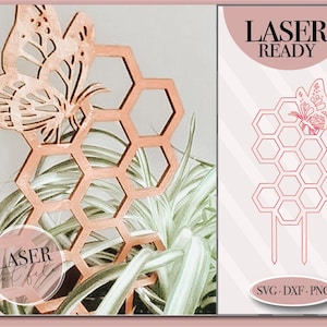 Op de afbeelding: Lasergesneden ontwerp van een honingraat met een vlinder erop. Het ontwerp is klaar om op een lasersnijder te worden gesneden. Het ontwerp is in SVG, DXF en PNG-formaten. De tekst "Laser Cut File" en "Laser Ready" is zichtbaar in de afbeelding.
