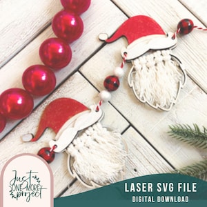 May include: A digital download of a laser cut SVG file for a Christmas garland featuring two Santa faces with white yarn beards. The garland is decorated with red and black buffalo plaid and white beads.