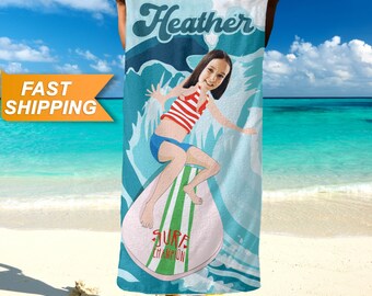 May include: A personalized beach towel with a cartoon illustration of a girl surfing. The towel is blue with white waves and the girl's name "Heather" is written in a retro font at the top. The text "Surf Champion" is written on the surfboard.
