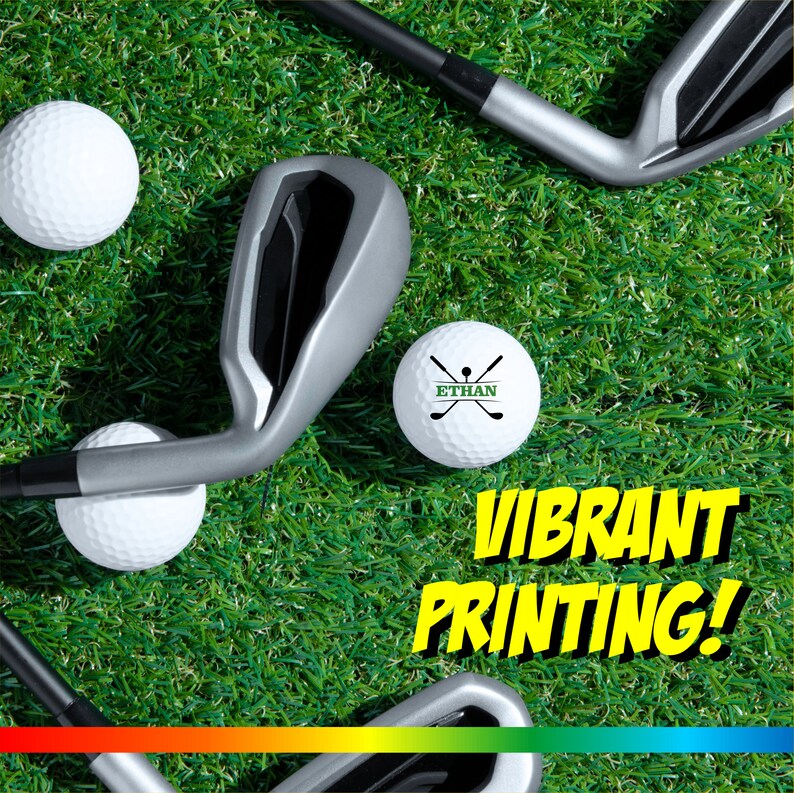 May include: Golf balls with a vibrant print design on a green grass background. The text "ETHAN" and a golf club design are printed on one of the golf balls. The text "VIBRANT PRINTING!" is printed in yellow on a black background.