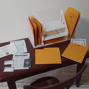 May include: Miniature office scene with a dark brown desk, chair, and white file organizers. The desk holds documents, folders, and a passport. The scene includes the word "PASSWORDS" on a document. The overall theme is a small-scale office setup.