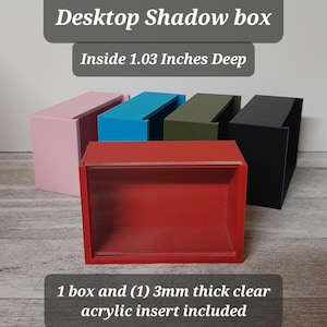 May include: A red desktop shadow box with a clear acrylic insert, 1.03 inches deep. The image shows the box alongside other boxes in pink, blue, green, and black. The text reads "Desktop Shadow box" and "Inside 1.03 Inches Deep."