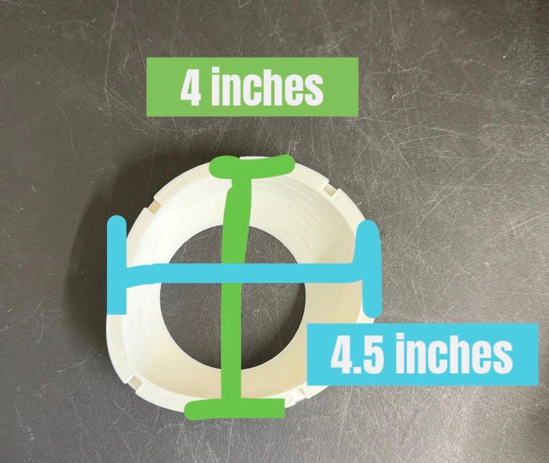Pode incluir: Um objeto circular branco com um exterior estriado. Uma linha verde indica uma medida vertical de 10,16 cm, enquanto uma linha azul indica uma medida horizontal de 11,43 cm, com etiquetas de texto correspondentes para cada dimens&atilde;o.
