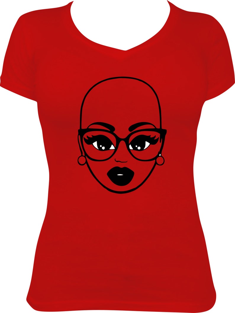 May include: A red V-neck t-shirt featuring a black and white graphic of a bald woman's face wearing glasses and earrings. The woman's lips are black. The graphic is centered on the front of the shirt.