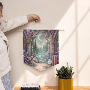 May include: A decorative wall hanging featuring a fantasy landscape with an arched doorway, a crescent moon, and a path leading into a forest. The artwork includes pink and purple flowers, and a compass.