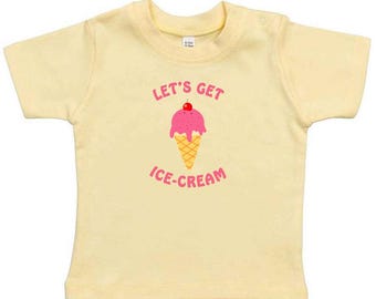 May include: A yellow short-sleeved t-shirt with the text "Let's Get Ice-Cream" and a cartoon ice cream cone with a cherry on top.