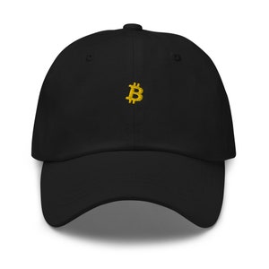 Könnte beinhalten: Eine schwarze Baseballkappe mit einem goldenen, gestickten Bitcoin-Symbol auf der Vorderseite.