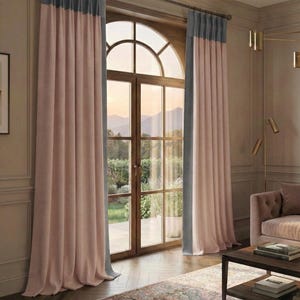 Könnte beinhalten: Zwei lange, rosa Vorhänge mit grauen Oberteilen hängen vor einem großen Bogenfenster. Die Vorhänge befinden sich in einem Raum mit einem gemusterten Teppich und einem Sofa. Das Fenster bietet einen Blick nach draußen. Die Vorhänge sind an einer dunklen Gardinenstange aufgehängt.
