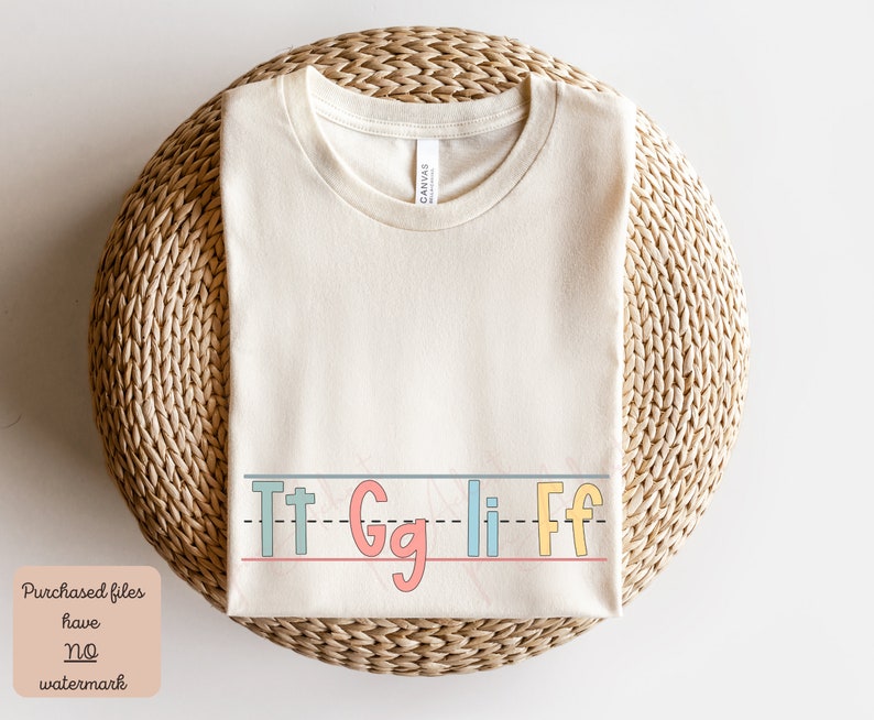 Pu&ograve; includere: Una maglietta beige con una riga di lettere che dice "Tt Gg Li Ff" in lettere colorate e contornate.