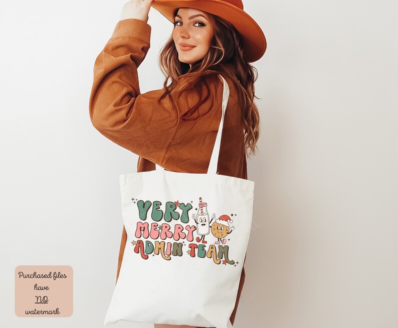 May include: White tote bag with the text "Very Merry Admin Team" in colorful, stylized letters. A cartoon milk carton and cookie with Santa hats are next to the text.