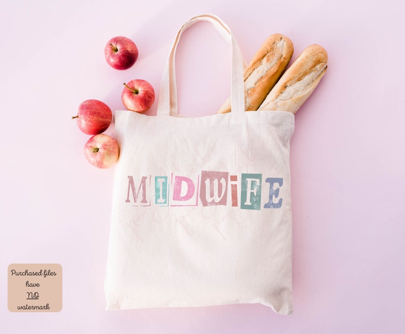 May include: A white canvas tote bag with the word "MIDWIFE" printed in colorful, block letters. The bag is filled with two loaves of bread and red apples. The bag is on a pink background.