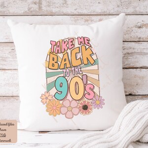 May include: White throw pillow with a colorful graphic design that says "Take Me Back to the 90's" with a retro sunburst design and flowers.
