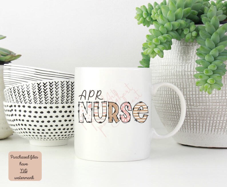 May include: White ceramic mug with a brown and pink graphic that says "APR NURSE". The mug has a black and white striped handle.