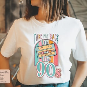 May include: White t-shirt with a retro design featuring a cassette tape and the text "Take Me Back to the 90s". The design is in a rainbow color scheme with a blue, pink, and yellow background.