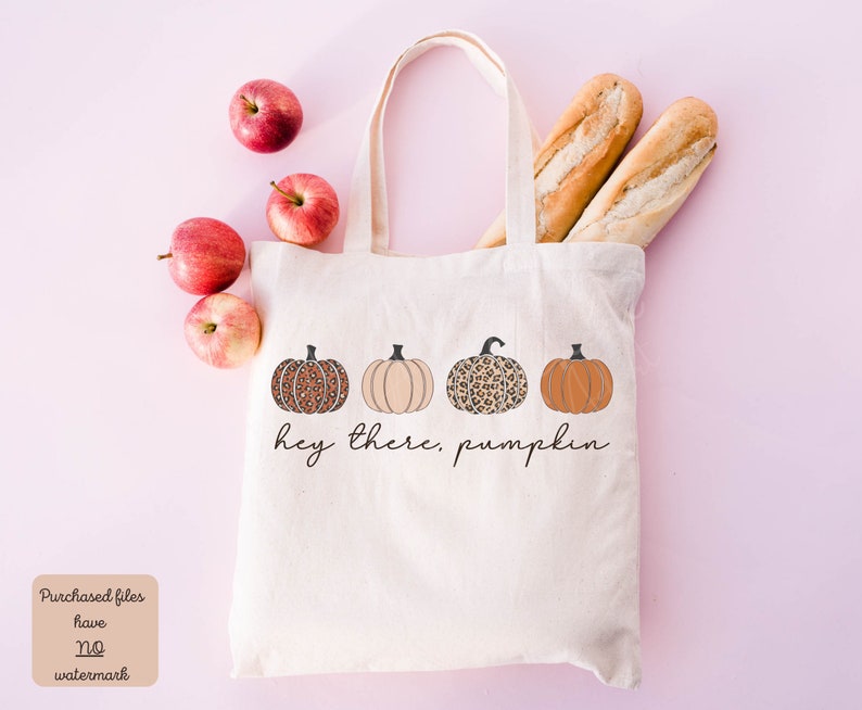 May include: A white canvas tote bag with the text "Hey there, pumpkin" printed on it. The bag features four pumpkins with different patterns, including leopard print and solid colors.