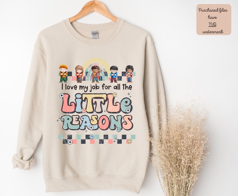 Pu&ograve; includere: Una felpa beige con un design grafico che presenta un gruppo di bambini e il testo "Amo il mio lavoro per tutte le PICCOLE RAGIONI".